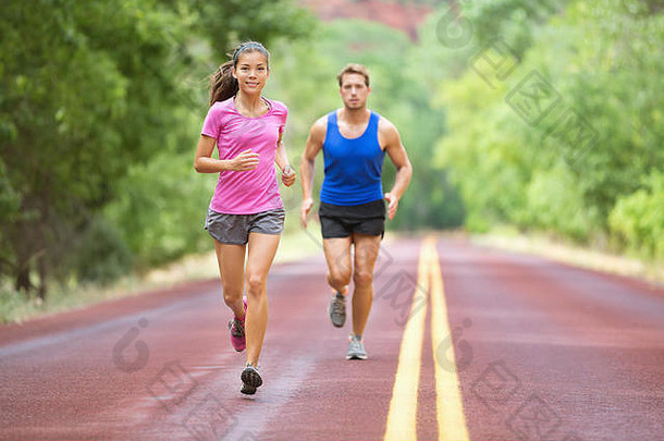 运行夫妇培训在户外路木马拉松混合比赛漂亮的年轻的女适合高加索人英俊的男人。二十多岁生活方式完整的数字