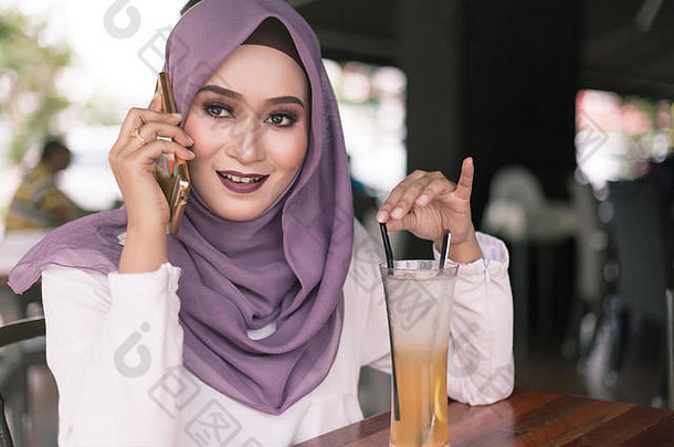 美丽的年轻的马来语女人电话调用咖啡馆铣削脸