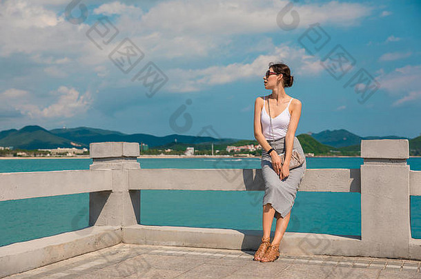 快乐的美丽的女孩休息有趣的假期码头背景城市中国海南城市三亚小镇三亚受欢迎的旅游