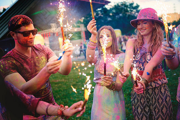 年轻的成年人覆盖彩色粉笔粉持有罗马焰火筒节日