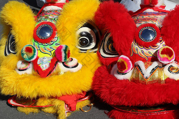特写镜头毛茸茸的色彩斑斓的跳舞狮子头饰红色的黄色的服装穿中国人月球年游行春天节日