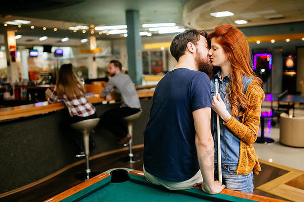 美丽的夫妇接吻台球酒吧日期