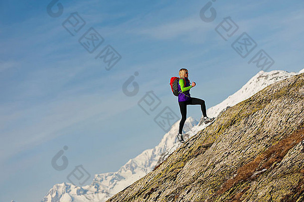 跑步者运行陡峭的山岩石脸高高度