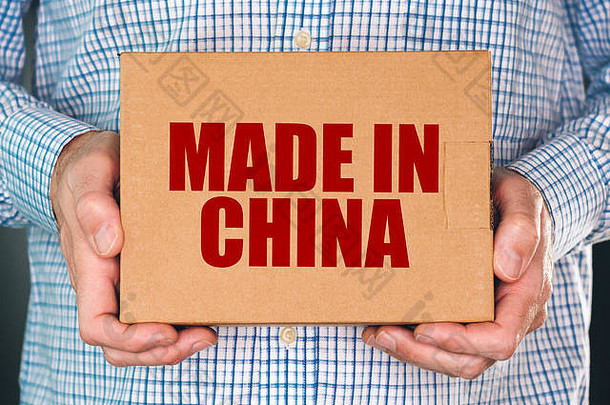 男人。持有纸板盒子产品包使中国标签印记商品货物进口东亚洲