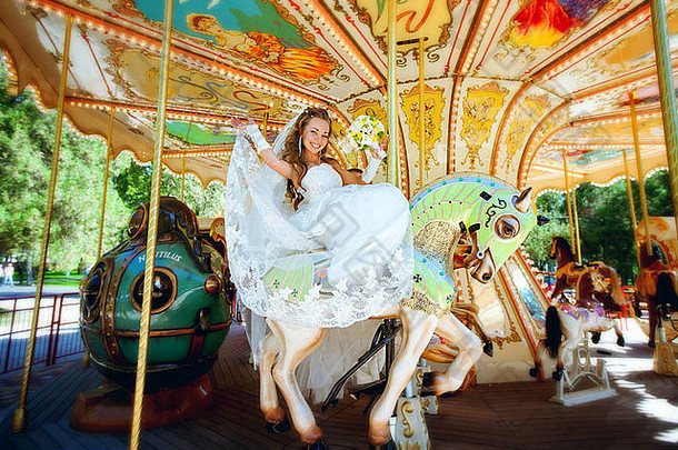 美丽的新娘骑旋转木马娱乐公园