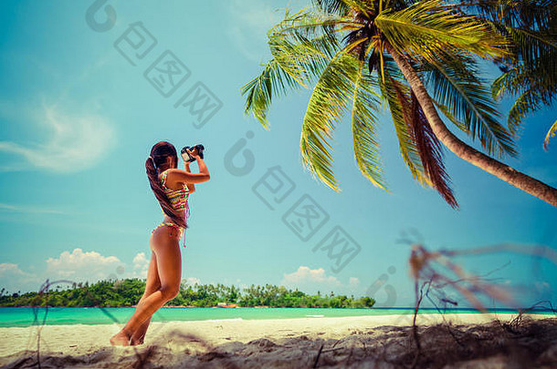 年轻的美丽的女孩比基尼采取图片自然景观背景沙子海滩棕榈
