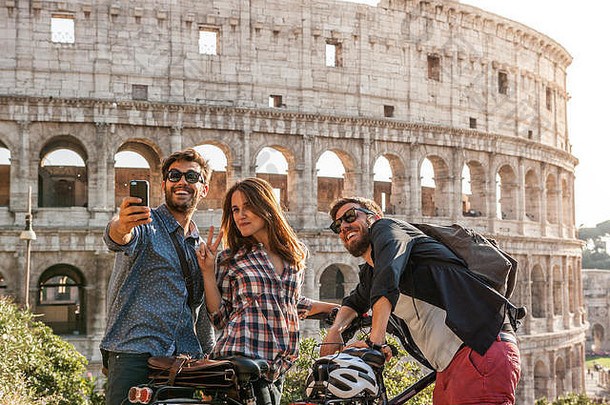 快乐年轻的朋友游客自行车罗马圆形大剧场罗马采取图片自拍智能手机