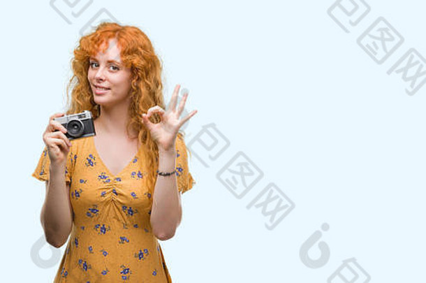 年轻的红色头发的人女人采取图片持有古董相机标志手指优秀的象征