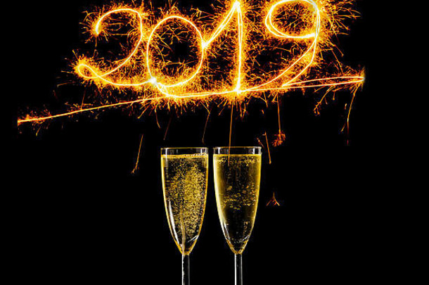 快乐一年眼镜香槟美丽的闪亮的金数字写闪耀烟花孤立的黑色的背景