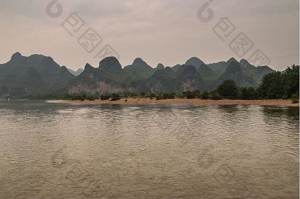 桂林中国河宽景观岩溶山范围棕色（的）多雨的天空棕色（的）岩石海岸线绿色