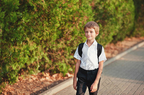 小学生回来学校好情绪男孩小径提高了眼睛天空微笑肩膀学生书包