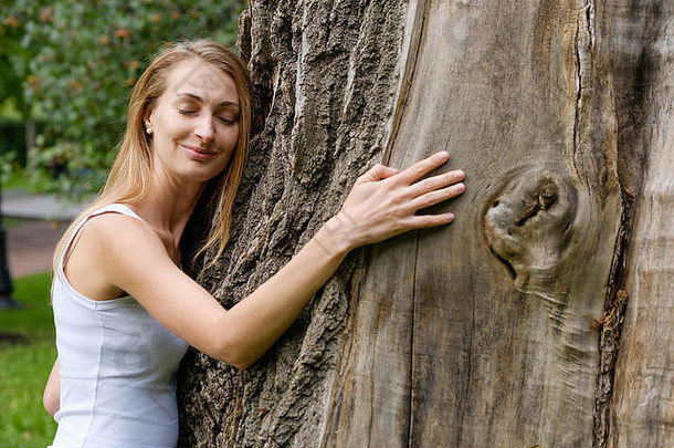 年轻的女人拥抱大树