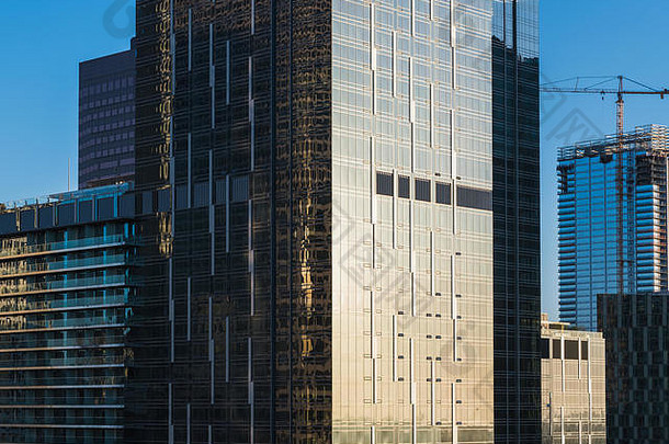 关闭视图密集的城市景观玻璃钢办公室住宅塔建设起重机反映光日落downtow