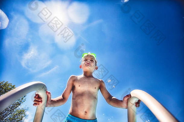 低角视图男孩游泳池梯蓝色的天空