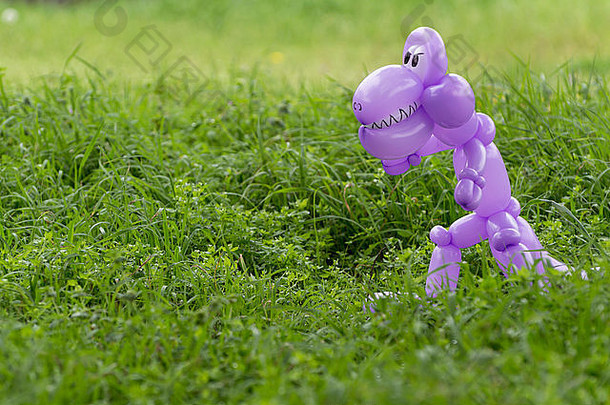 紫色的气球动物恐龙牙齿眼睛可怕的郁郁葱葱的绿色草回来院子里