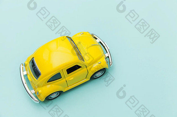 简单的设计黄色的古董复古的玩具车孤立的蓝色的柔和的色彩斑斓的背景汽车运输象征城市交通交付概念复制空间文本