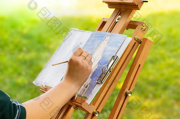 画开放空气木画架速写本未完成的绘画女手油漆塔石油油漆阳光明媚的开花米德