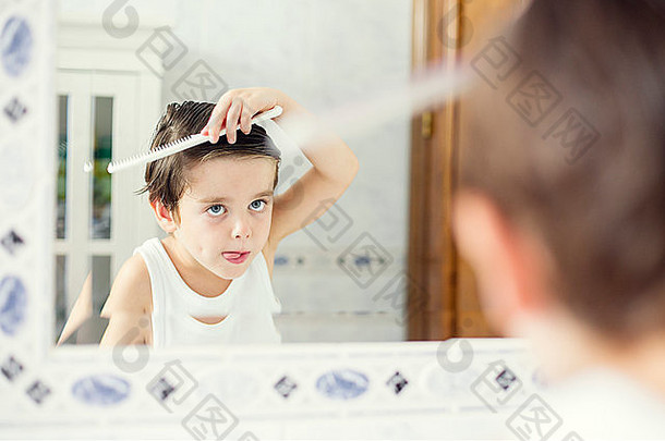 男孩站前面镜子梳理头发