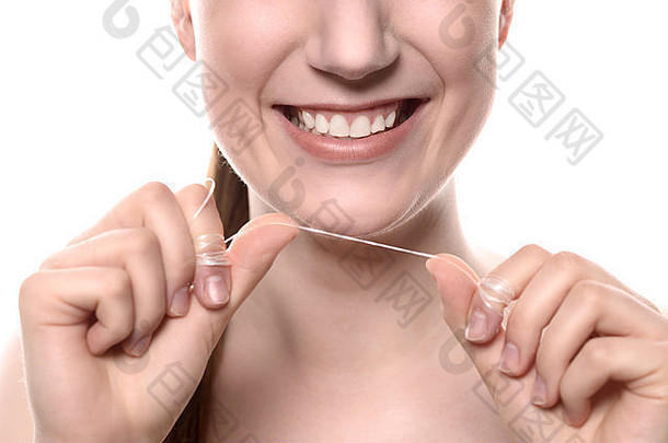 关闭微笑有吸引力的年轻的女人健康的白色牙齿持有长度牙科牙线