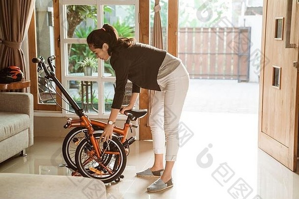 年轻的企业家女人准备折叠自行车首页