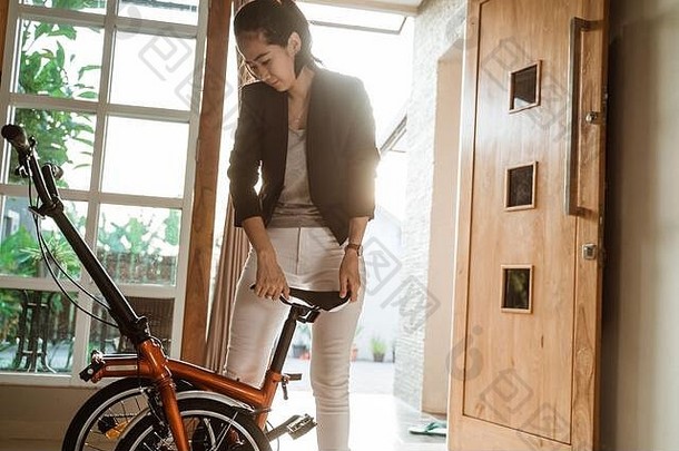 亚洲年轻的女人站生活房间开放褶皱折叠自行车