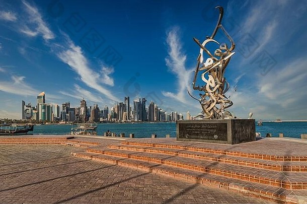 多哈回合谈判<strong>卡塔尔</strong>天际线日光视图云天空显示摩天大楼独桅帆船背景书法雕塑前景