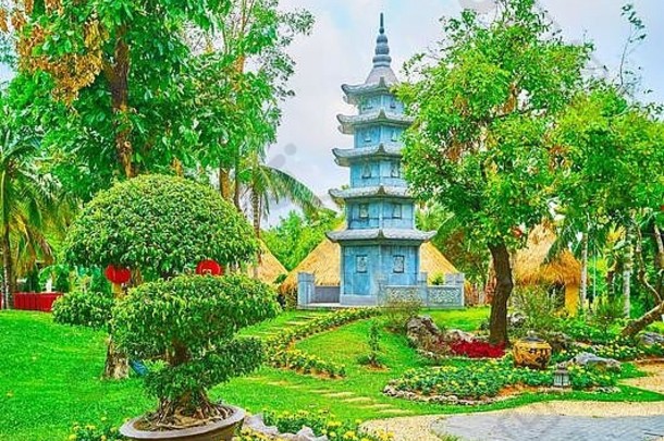 享受观赏中国花园penjingpun-saipenzai树花床绿色草坪上真实的石头宝塔背景拉贾普鲁克由