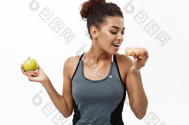 健康的饮食概念美丽的运动非洲美国使决定甜甜圈绿色苹果孤立的白色背景