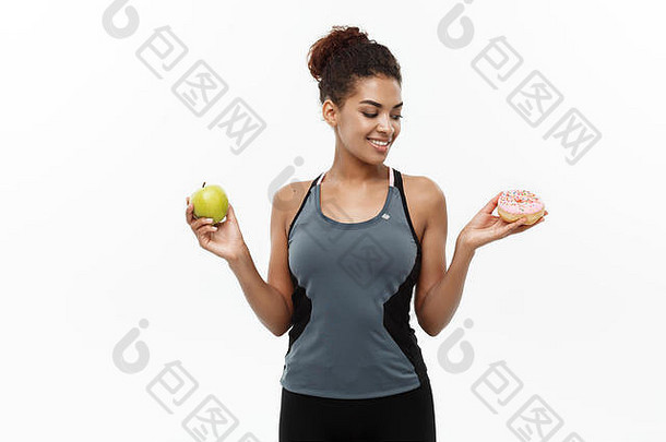 健康的饮食概念美丽的运动非洲美国使决定甜甜圈绿色苹果孤立的白色背景
