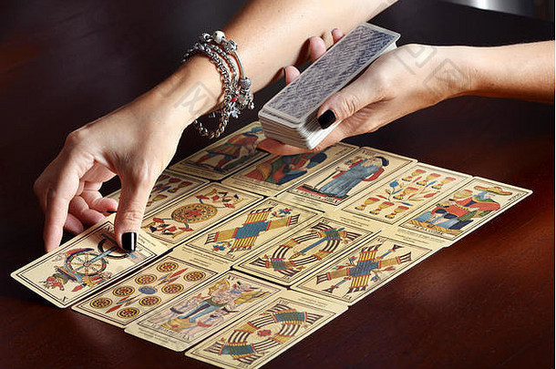 女《财富》杂志出纳员手传播古董塔罗牌卡片黑暗表格表面
