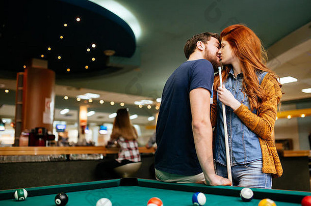 美丽的夫妇接吻台球酒吧