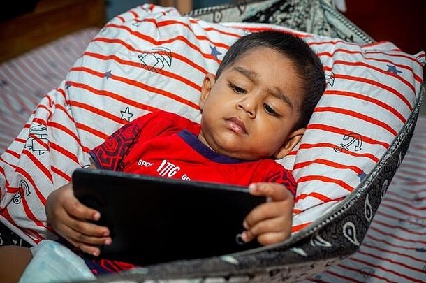 睡眠孩子说谎自制的吊床看漫画智能手机选项卡孩子们玩智能手机移动电话