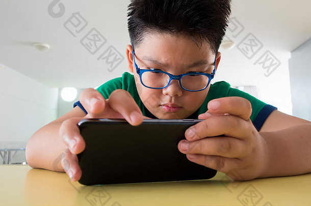 关闭亚洲男孩玩智能手机