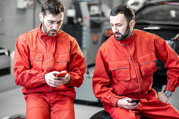 车服务工人红色的统一的打破坐着电话轮子轮胎越来越多的服务
