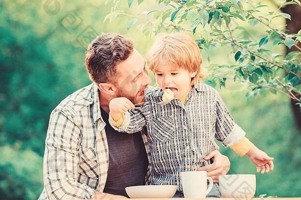 准备食物健康的食物节食快乐家庭快乐父亲一天男孩爸爸儿子父亲吃牛奶粥童年幸福食物习惯爱概念
