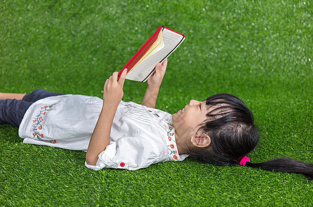 亚洲中国人女孩说谎草阅读书户外公园