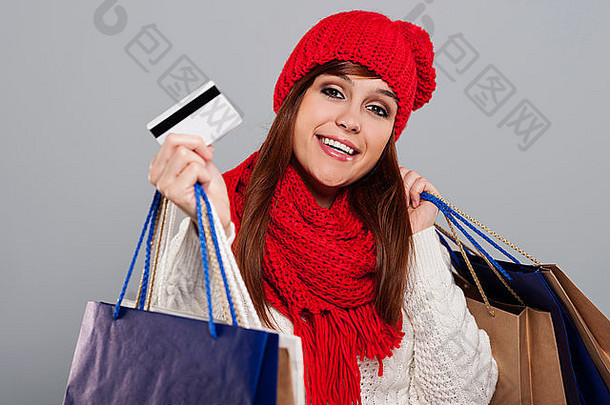 微笑女人冬天衣服显示信贷卡持有购物袋debica波兰