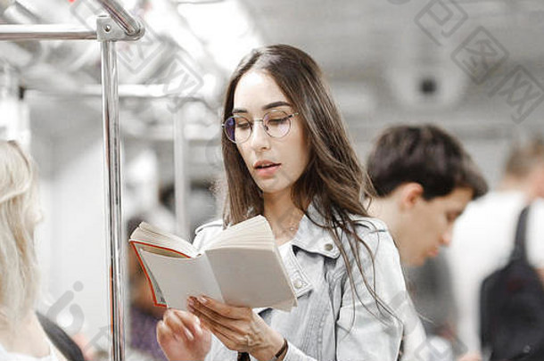 女孩阅读书地铁中间人群