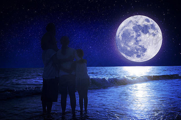 家庭站海滩看月亮庆祝中秋节日