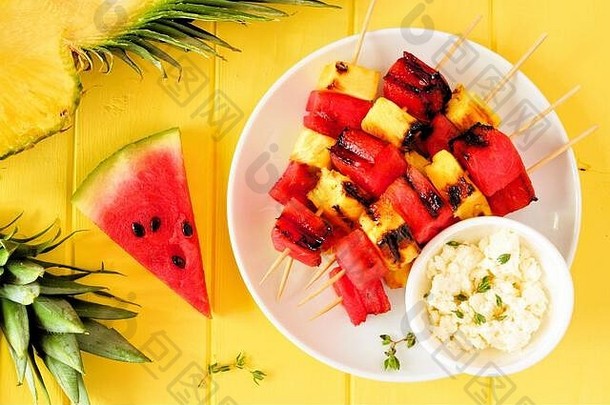 烤西瓜菠萝水果串羊视图明亮的黄色的木背景夏天食物概念