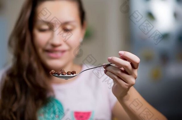 年轻的女人持有空气勺子巧克力片牛奶吃前面视图