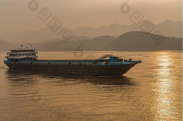 重庆中国晚上光长江河穿着<strong>蓝黑色</strong>驳船帆金日落反映了棕色（的）水前面商店