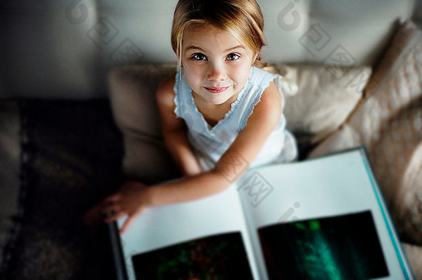 高加索人女孩阅读书沙发