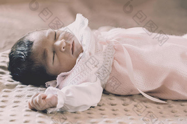 可爱的周新生儿婴儿女孩穿软粉红色的针织衣服睡觉和平床上新生儿婴儿女孩睡觉睡着了说谎床上孩子