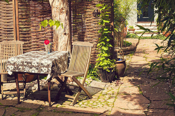 图像浪漫的阳光明媚的后院木家具鹅卵石