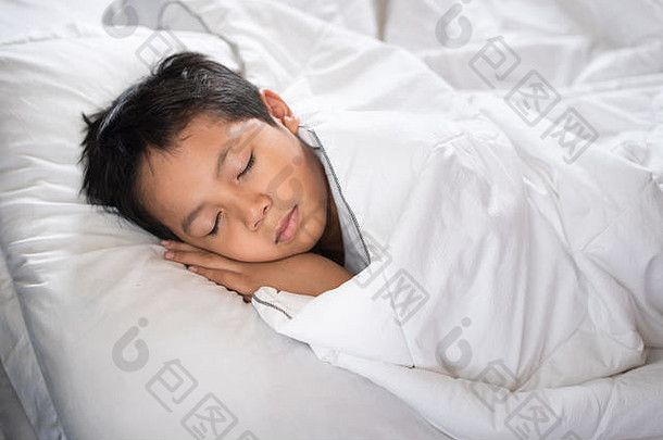 男孩睡觉床上白色表枕头亚洲孩子秋天睡着了做白日梦睡眠概念