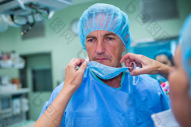 护士帮助外科医生系外科手术面具