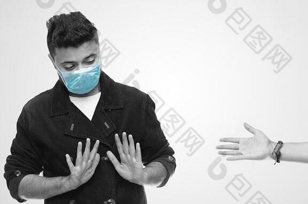 社会距离年轻的男人。穿外科手术面具避免握手安全保护冠状病毒流感大流行握手