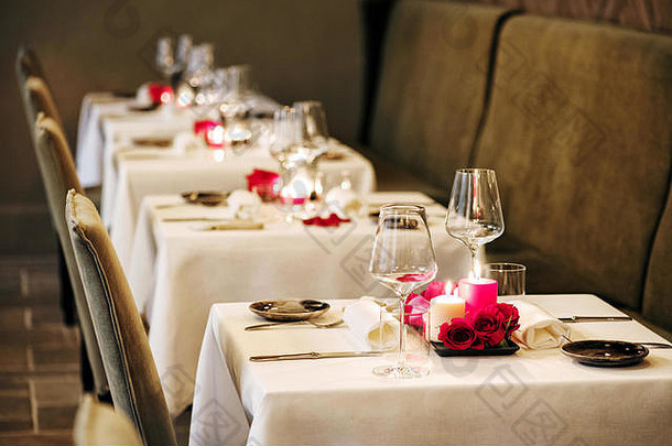 浪漫的表格设置餐厅重心燃烧蜡烛红色的玫瑰优雅的玻璃器皿亲密的晚餐