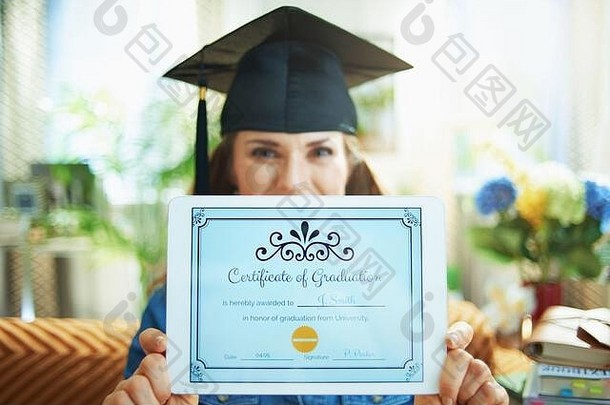 特写镜头女人毕业帽显示电子证书毕业平板电脑屏幕生活房间阳光明媚的一天